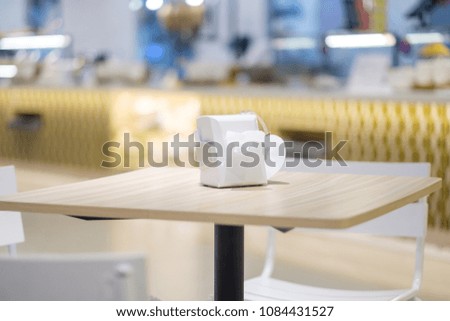 Chairs and tables in modern food court at mall with tissues despencer on it
