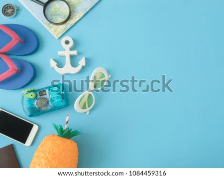 top view travel concept with waterproof camera, smartphone, map, compass and Outfit of traveler on blue background with copy space, Tourist essentials, vintage tone effect