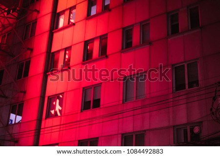 Red and purple reflecting lights in the building. Holographic neon colors.