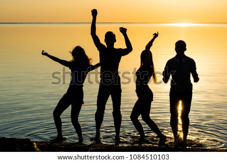Young people, guys and girls, students are dancing at sunset background, silhouettes
