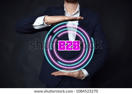 In the hands of a businessman, a neon circle with the inscription:B2B