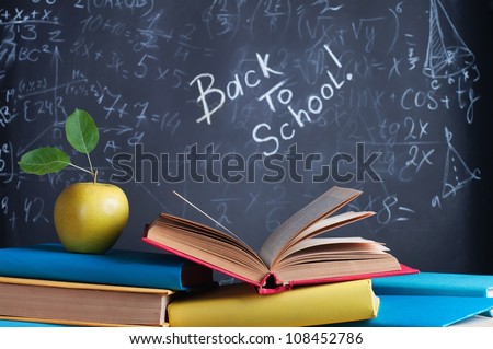 Books on the background of the school board Royalty-Free Stock Photo #108452786