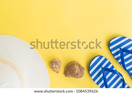 Summer hat and flip flops on a yellow background. Top view, flat lay