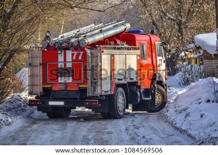 Russia. The red fire truck is moving to the fire in the yards. Winter. Snow. Royalty-Free Stock Photo #1084569506
