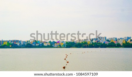 A view of the city from other side of an artidficial lake in Madiwala,Bengaluru.The water can be seen covered by fishing nets.