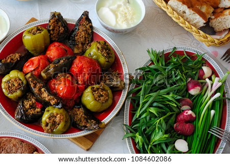 Azerbaijani dolma with eggplant, tomato and pepper, yogurt, greenery and bread on the table Royalty-Free Stock Photo #1084602086