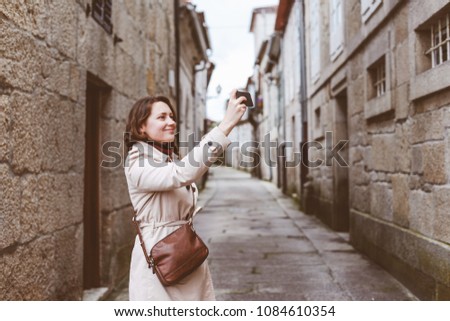 A young pretty woman taking a selfie on the old street of Europe