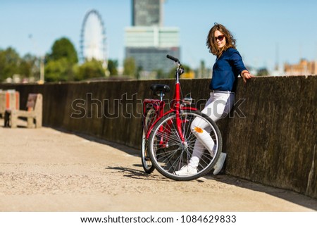 Urban biking - young woman and bike in city 