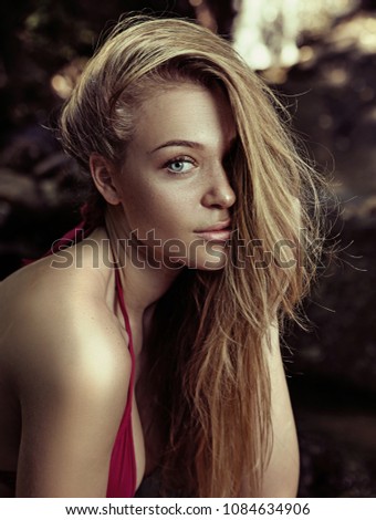 Attractive woman posing at a pond in the middle of the jungle