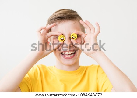 Cheerful laughing teen boy with yellow smiley faces instead of eyes