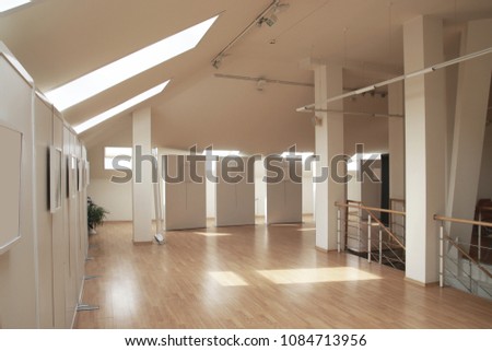 Modern art museum exhibition hall wooden floor. Perspective view of empty space office room. Blank frames. Shade on wall for gallery interior. Use as template to mock up or display office furniture.