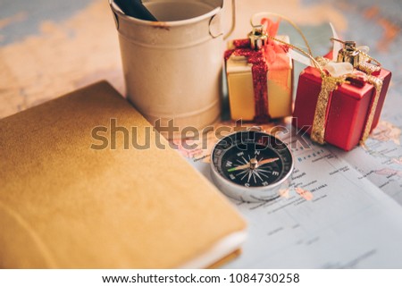 Planner To Do List for trip. Open daily, a compass, pen, camera, gift and a notebook on the desktop with maps. Close up and Travel Concepts.