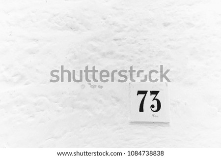 Number 73 on a white wall