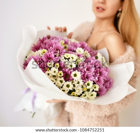 Beautiful woman hold bouquet of chrysanthemum flowers yellow and purple on white background