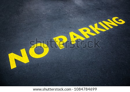 Yellow words no parking painted on the road asphalt