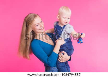 happy little girl and her mother having fun over pink background
