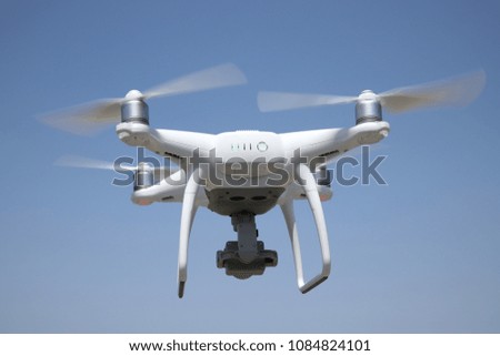 Close up of white drone flying in air and clear blue sky background 