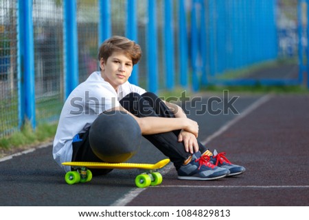 cute young sporty boy in white t shirt plays basketball on his free time, holidays, summer day. Sport  health lifestyle concept