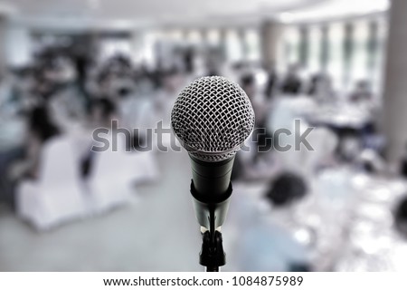 Microphone on boom stand ready for the meeting ,blurred background group of people sitting around table. Microphone on stage in conference hall. Let's talk