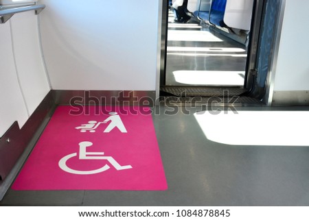 facilities space area for disabled and baby stroller in railways, white disabled and baby stroller sign on pink background, copy space