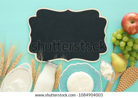 Top view image of dairy products over white wooden background. Symbols of jewish holiday - Shavuot