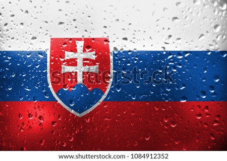 Texture of Slovakia flag on the glass with drops of rain.