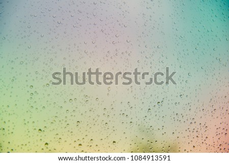 The Iridescent texture of the drops on the glass.