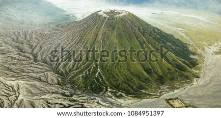 Aerial view of mountain terrain and erosion the surface around the volcano at Batok Indonesia. Beautiful bird eyes view of nature and landscape. Top view from drone. Texture of the earth.