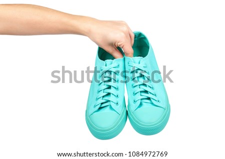 Turquoise rubber sneakers with hand, casual footwear isolated on white background.
