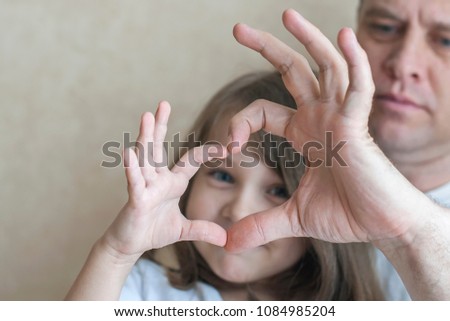 Portrait of happy loving family. Father and his daughter child girl playing. Cute baby and daddy. Concept of Father day. Family holiday and togetherness. Forming heart with hands as symbol of love 