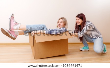 Photo of blonde in cardboard box and brunette