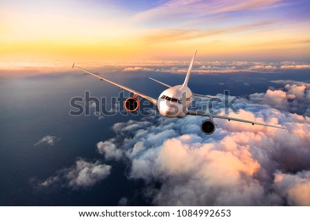 Passengers commercial airplane flying above clouds, front view. Concept of fast modern travel Royalty-Free Stock Photo #1084992653