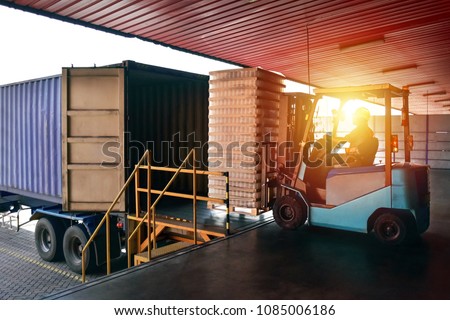Forklift handling empty tin cans from container into warehouse. Distribution, Logistics Import Export, Warehouse operation, Trading, Shipment, Delivery concept. Royalty-Free Stock Photo #1085006186