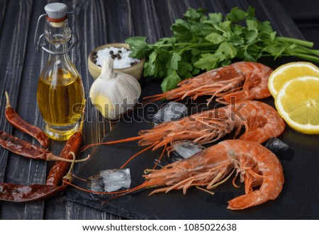 Raw fresh prawns langostino austral shrimp seafood with lemon and spices.