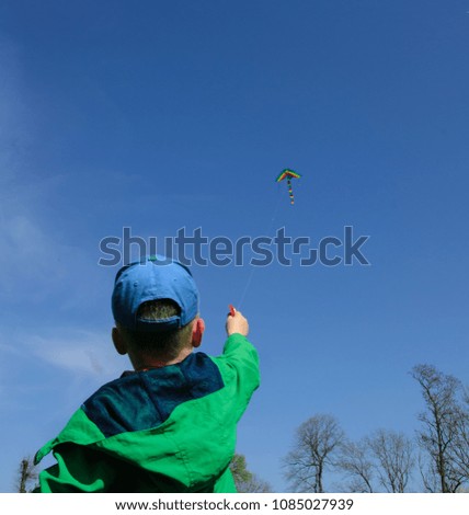 The baby starts the kite.he holds in the hand of the kite.