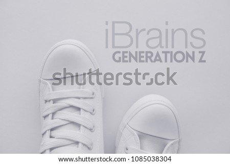 iBrains or Generation Z concept. Member of so called selfie generation in white casual canvas shoes standing over the title, top view Royalty-Free Stock Photo #1085038304