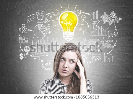 Pensive young woman wearing a striped shirt standing with her hand near the forehead and thinking. A chalkboard background with a business idea sketch