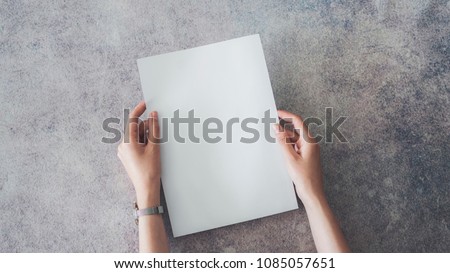 Female hands holding blank white paper
