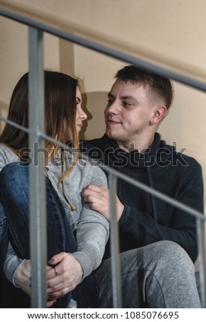 Homeless teenagers boyfriend and girlfriend sit on the steps in block of flats