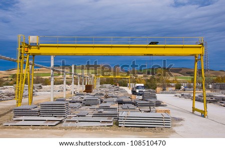 Yellow gantry crane with construction elements Royalty-Free Stock Photo #108510470