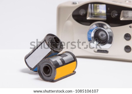 old film camera and photographic film on white background