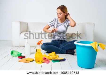  a bucket of water, a housewife sitting on the floor with rags, general cleaning                              