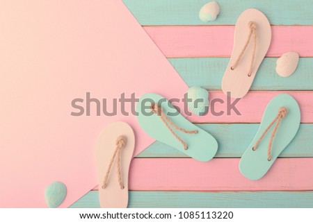 Colored flip flops, seashells and paper for your text on Soft pink and light mint wooden planks background Trendy vanilla pastel colors Top view and copy space Flat lay Summer design 