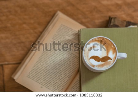 Cappuccino with a mustache pattern and books