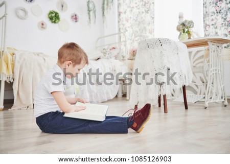 Cute little boy is going to school for the first time. Child with bag and book. Kid makes a briefcase, child room on a background.