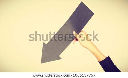 Planning, directions, choices concept. Man holding black arrow pointing right down. Indoor shot on light background