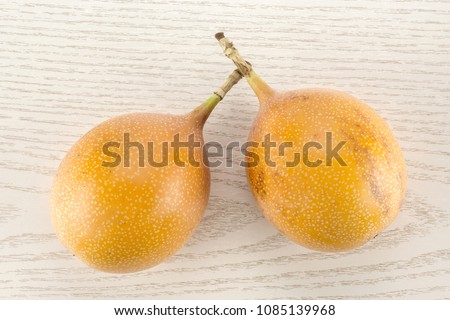 Two giant grenadilla table top isolated on grey wood background sweet fresh yellow passion fruit

