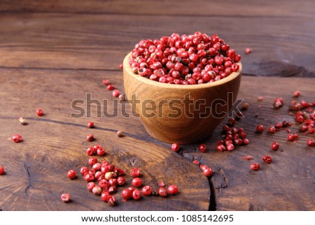 Red bell pepper in a bowl on a wooden background.