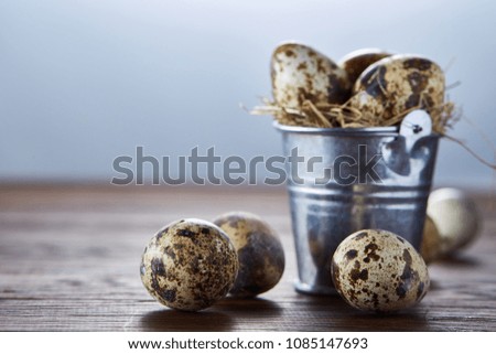 Small decorative bucket filled with quail eggs dark wooden table, close-up, selective focus.