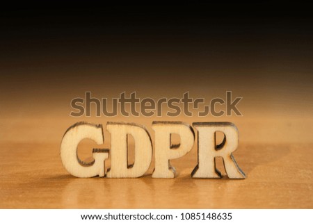 The word 'gdpr' made of wooden letters. wood inscription on table and dark black background